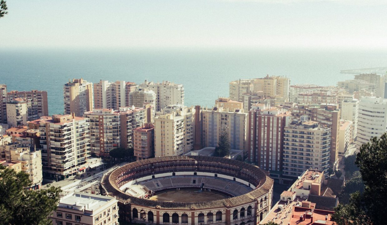 round stadium surrounded by buildings near the sea