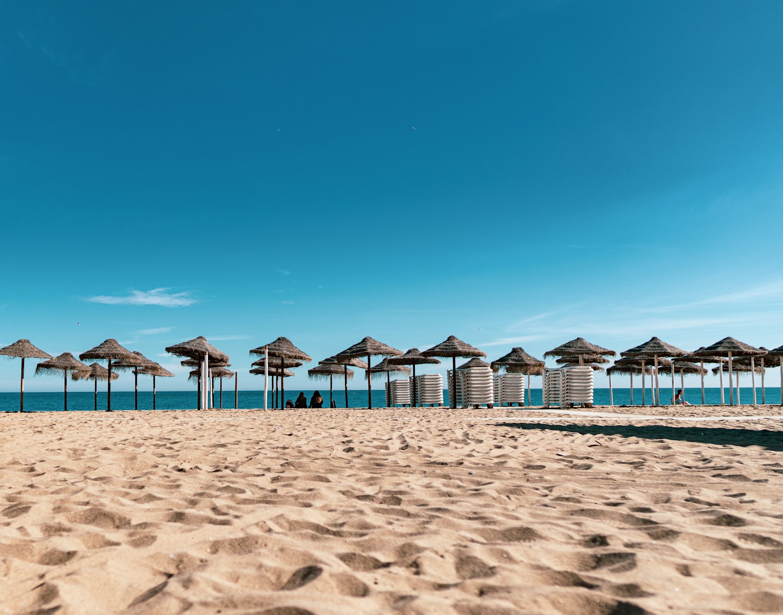 brown and white beach umbrellas on beach during daytime